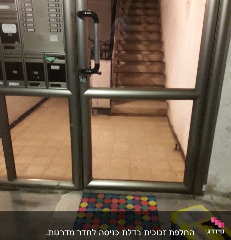 דלת זכוכית עם ידית שחורה בכניסה לבניין